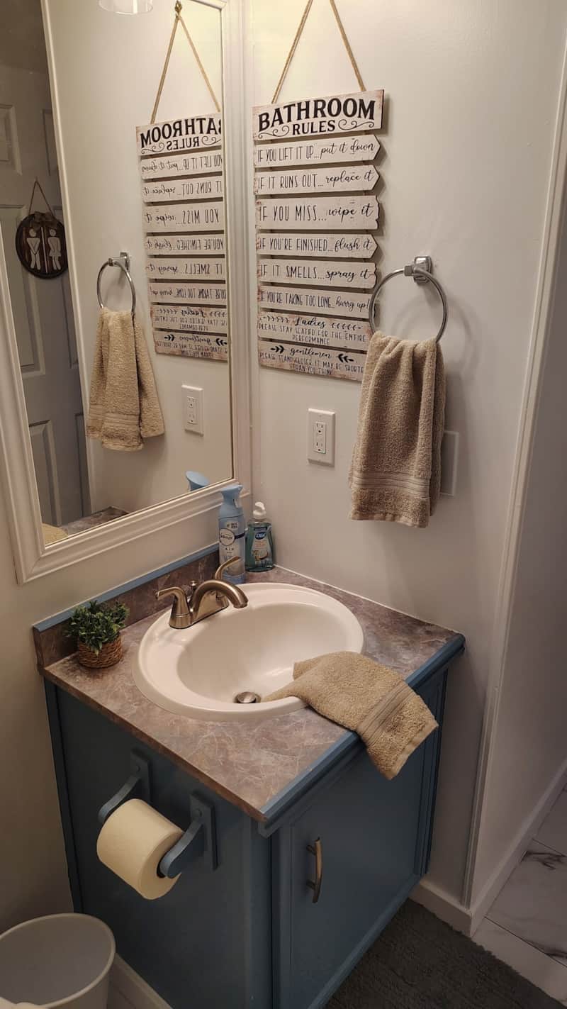 Bathroom vanity with blue cabinet, marble-look countertop, and oval sink at Lichner Resort Stays