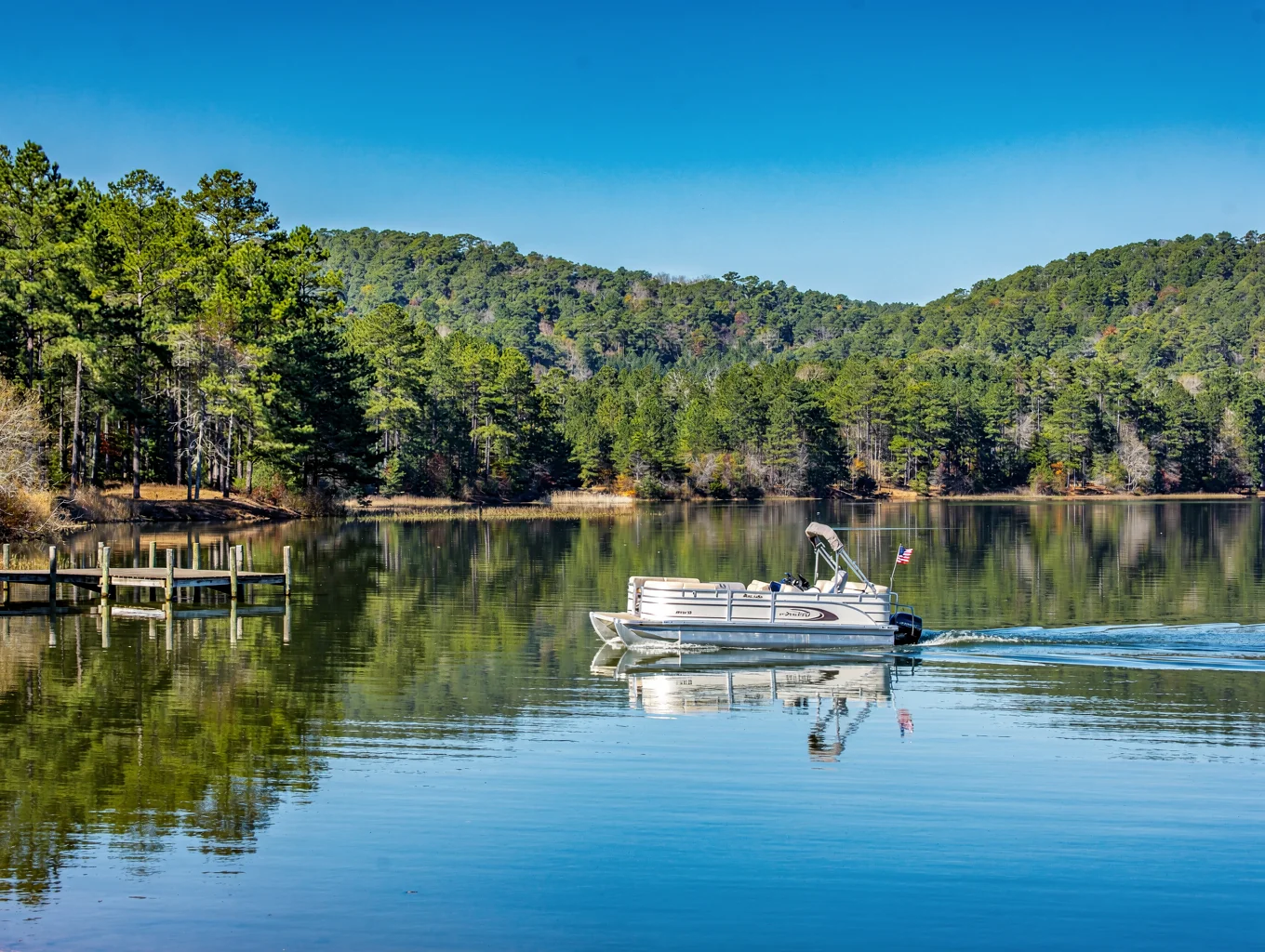 Pontoon boat floating on calm water in Norfork Lake Arkansas